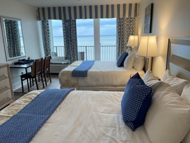 bedroom with a water view and hardwood / wood-style floors