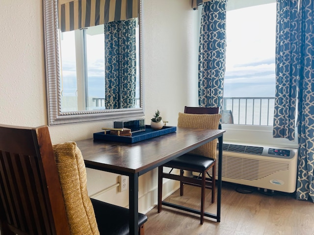 dining room featuring plenty of natural light, a water view, and hardwood / wood-style flooring