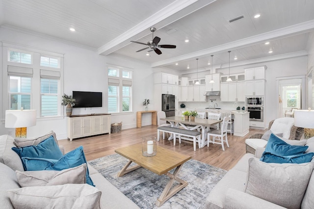 living room with plenty of natural light, beamed ceiling, and light hardwood / wood-style floors