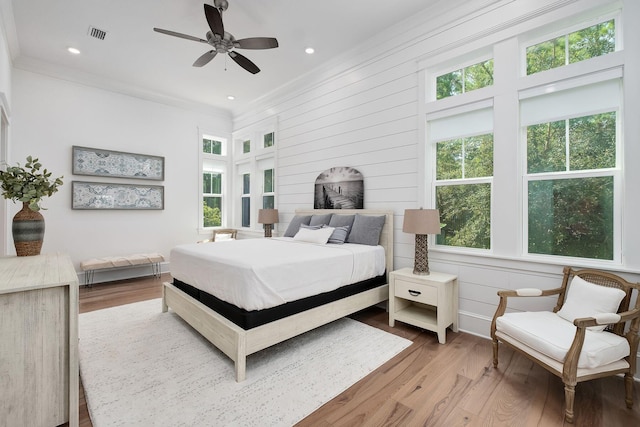 bedroom featuring ceiling fan, light hardwood / wood-style flooring, and ornamental molding