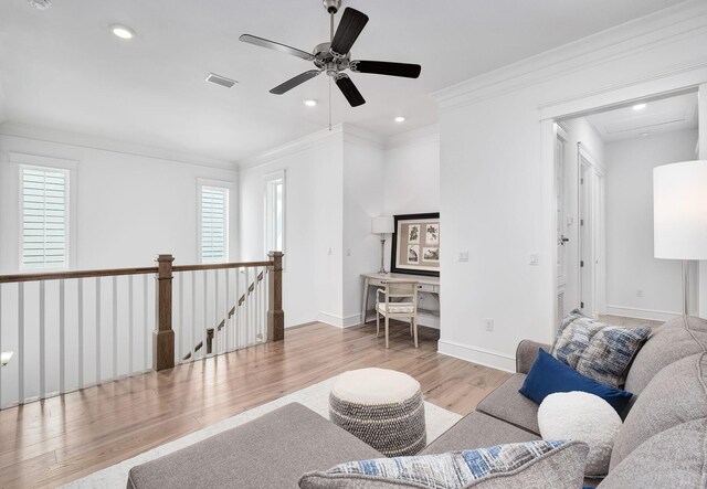 living room with ceiling fan, ornamental molding, and light wood-type flooring