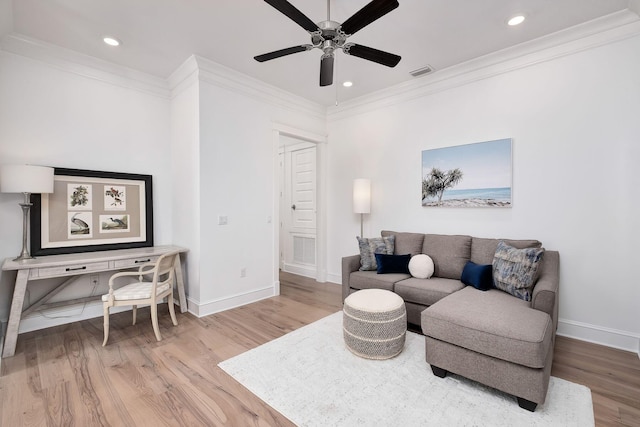 living room with crown molding, wood finished floors, baseboards, and ceiling fan