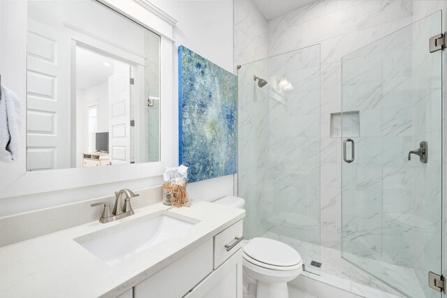 bathroom with vanity, walk in shower, and toilet