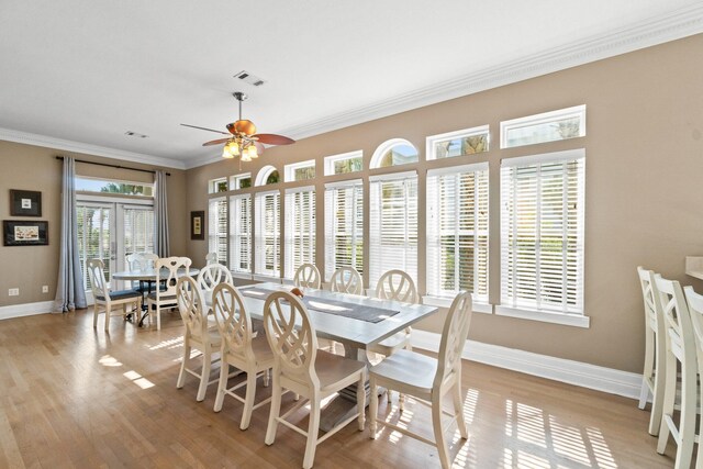 dining space featuring ceiling fan, french doors, ornamental molding, and light hardwood / wood-style floors