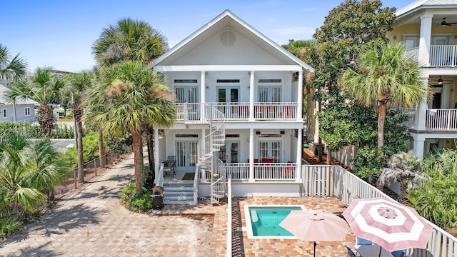 view of front of property with french doors, ceiling fan, and a balcony