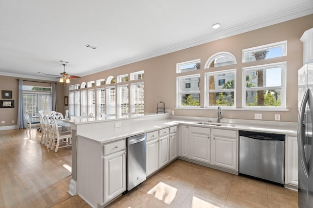 kitchen with stainless steel appliances, sink, white cabinets, and kitchen peninsula