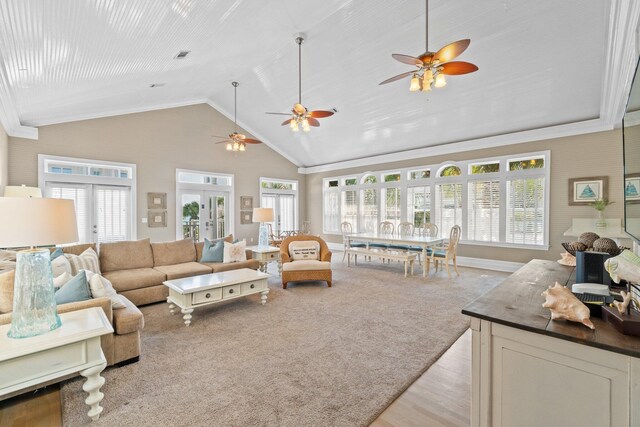 carpeted living room featuring french doors, a healthy amount of sunlight, and high vaulted ceiling