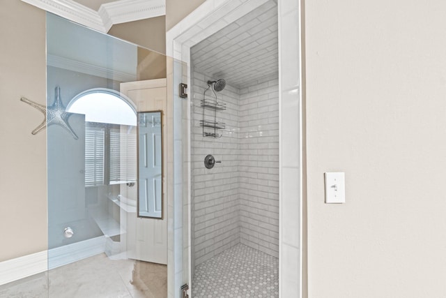 bathroom featuring ornamental molding and tiled shower