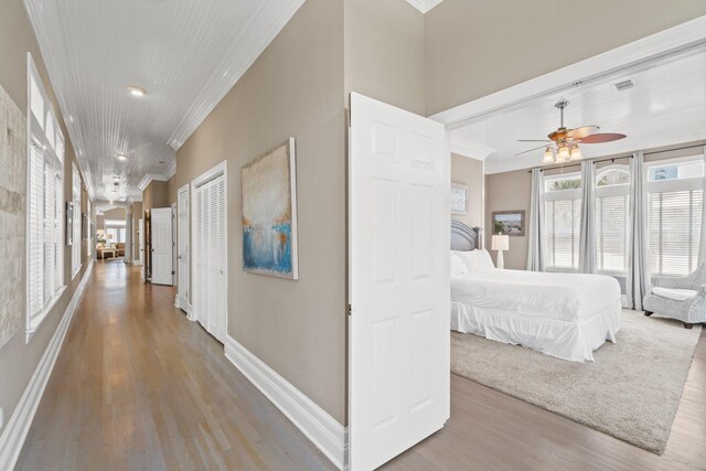 bedroom featuring ceiling fan, crown molding, and light hardwood / wood-style floors