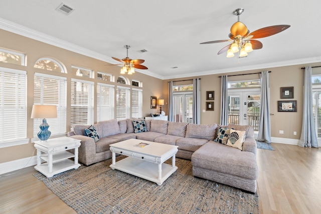 living room featuring light hardwood / wood-style floors, ornamental molding, and french doors