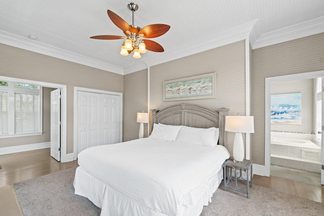 bedroom featuring ceiling fan, ensuite bathroom, crown molding, hardwood / wood-style flooring, and a closet