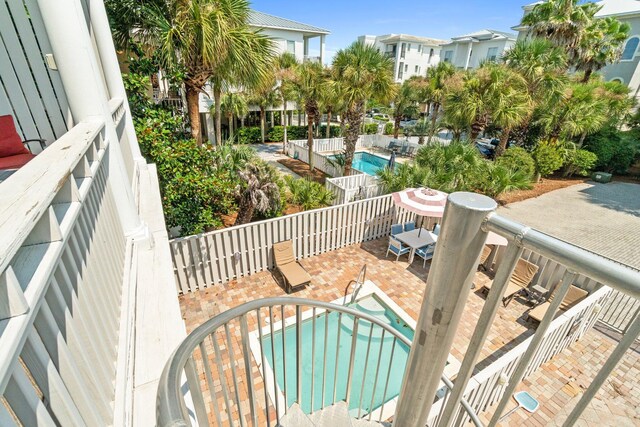 balcony with a patio and a fenced in pool