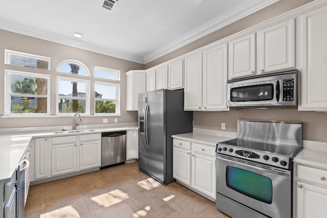 kitchen with sink, ornamental molding, stainless steel appliances, and white cabinets