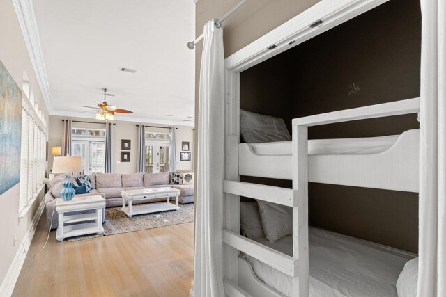 bedroom featuring ceiling fan, light hardwood / wood-style flooring, french doors, and crown molding