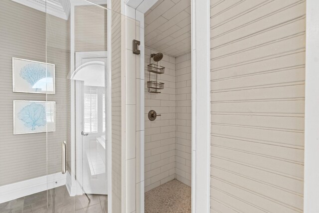 bathroom with a tile shower and a healthy amount of sunlight