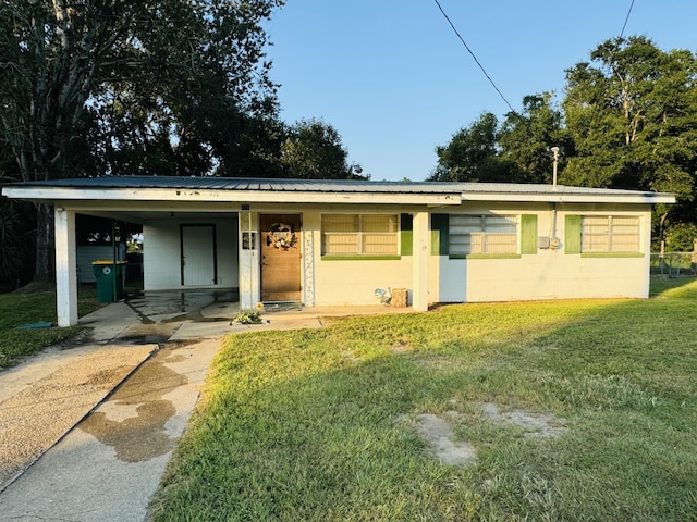 ranch-style house featuring a front lawn and a carport