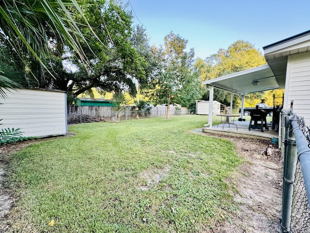 view of yard with a storage shed and a patio area