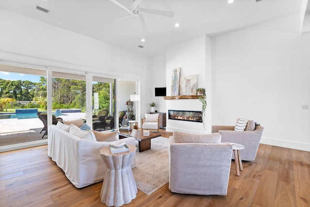 living room featuring ceiling fan and light hardwood / wood-style flooring