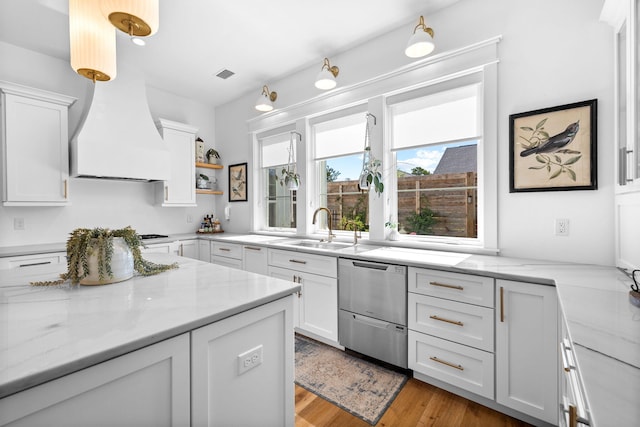 kitchen featuring white cabinets, light hardwood / wood-style flooring, and light stone counters