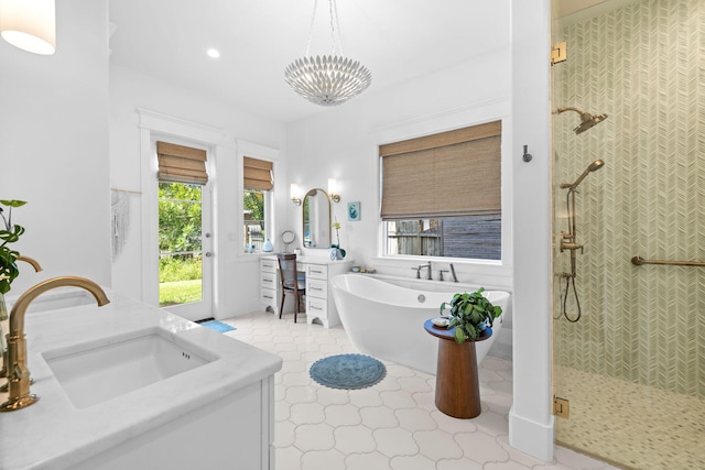 bathroom with double vanity, plus walk in shower, an inviting chandelier, and tile patterned floors