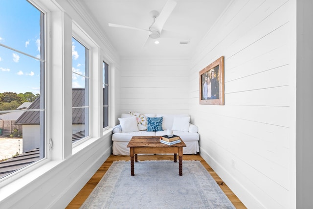 sunroom featuring ceiling fan and plenty of natural light