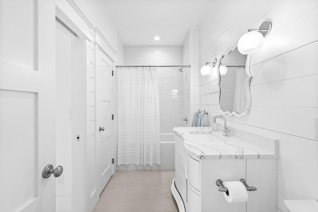 bathroom with shower / bathtub combination with curtain, tile walls, and vanity