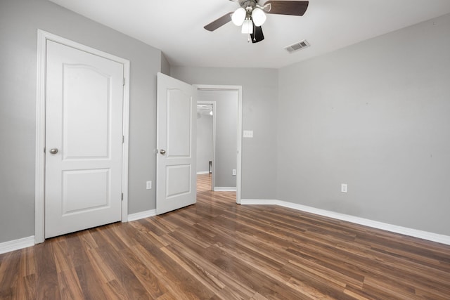 unfurnished bedroom with a ceiling fan, visible vents, baseboards, and wood finished floors