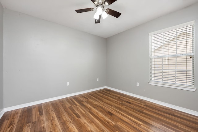 empty room with a ceiling fan, baseboards, and dark wood-style flooring