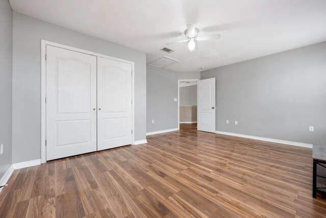 unfurnished bedroom featuring ceiling fan, a closet, and hardwood / wood-style flooring