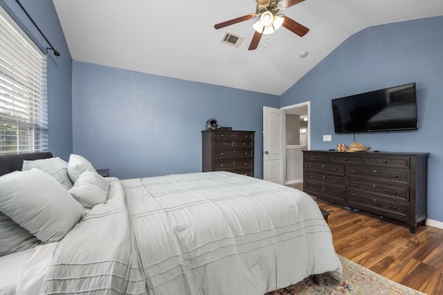 bedroom featuring visible vents, ceiling fan, vaulted ceiling, wood finished floors, and baseboards