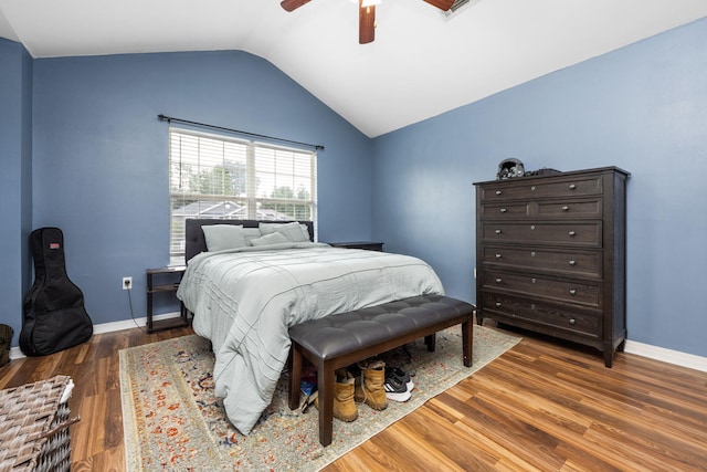 bedroom with a ceiling fan, lofted ceiling, baseboards, and wood finished floors