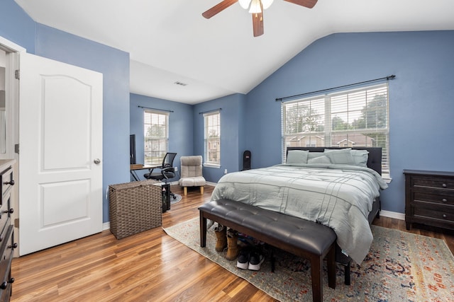 bedroom featuring visible vents, light wood-style flooring, vaulted ceiling, ceiling fan, and baseboards