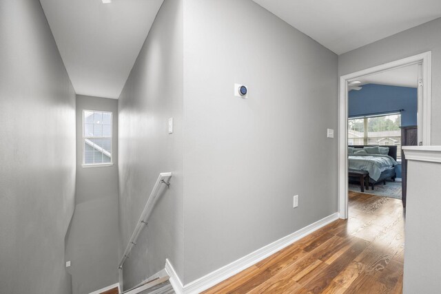 hall with wood-type flooring and lofted ceiling