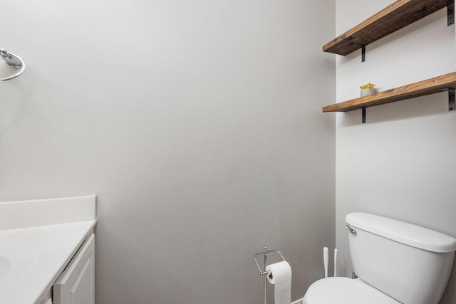 half bathroom featuring vanity and toilet