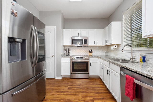 kitchen with appliances with stainless steel finishes, dark wood-type flooring, sink, and white cabinets