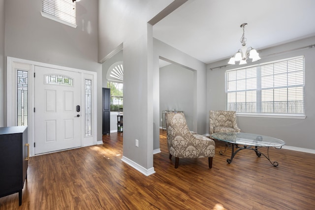 entryway featuring dark wood-type flooring and a chandelier