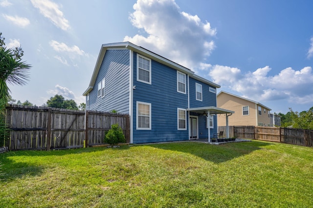 rear view of house featuring a fenced backyard and a lawn