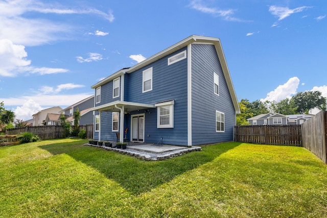 rear view of house featuring a patio, a lawn, and a fenced backyard