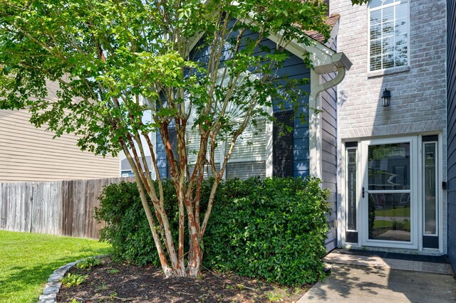 entrance to property with brick siding and fence