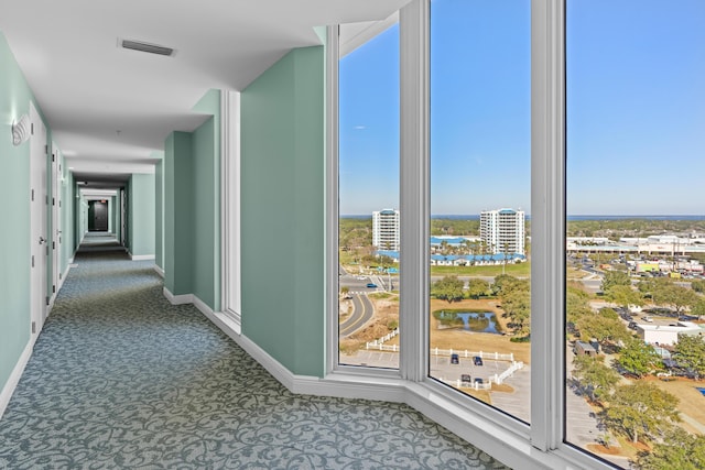 15100 Emerald Coast Pkwy Ph 2, Destin, FL 32541 - hall with baseboards, visible vents, a water view, dark colored carpet, and a city view