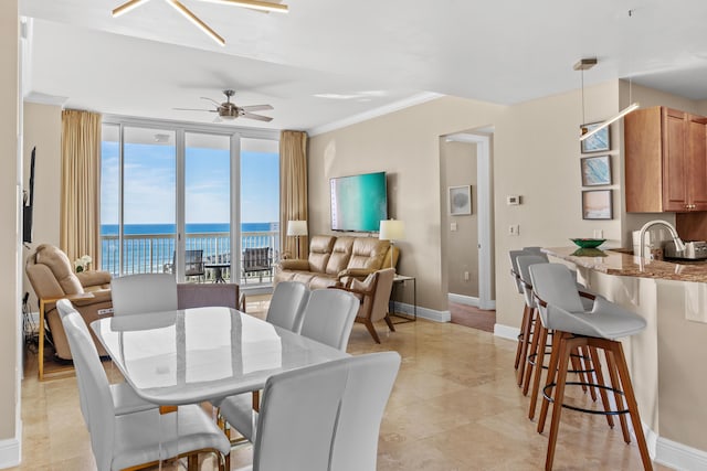 dining area with ceiling fan, light tile patterned flooring, baseboards, ornamental molding, and floor to ceiling windows