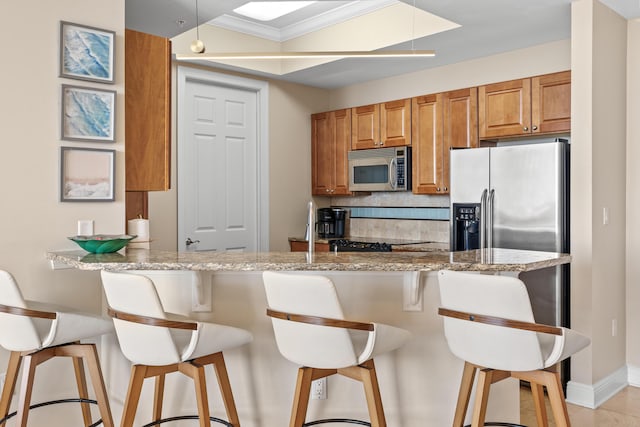 15100 Emerald Coast Pkwy Ph 2, Destin, FL 32541 - kitchen featuring stainless steel appliances, tasteful backsplash, a peninsula, and light stone countertops