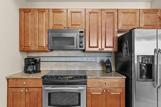 15100 Emerald Coast Pkwy Ph 2, Destin, FL 32541 - kitchen featuring brown cabinets, tasteful backsplash, and stainless steel appliances