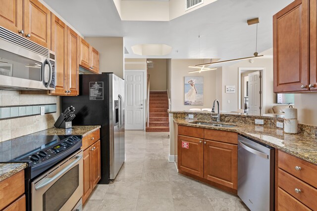 15100 Emerald Coast Pkwy Ph 2, Destin, FL 32541 - kitchen with stainless steel appliances, light stone counters, a sink, and brown cabinets