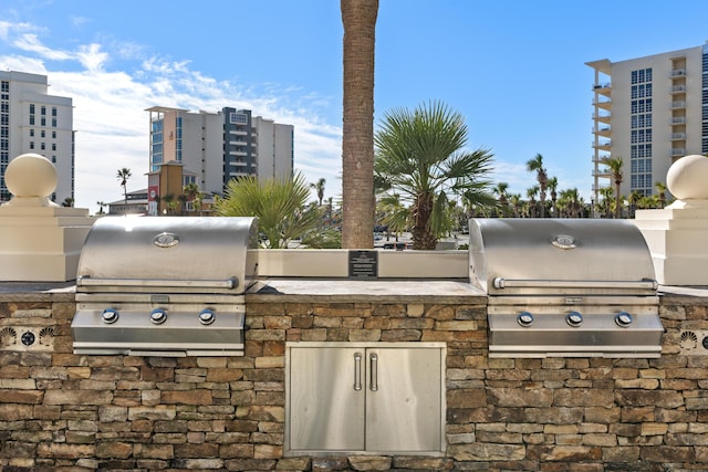 15100 Emerald Coast Pkwy Ph 2, Destin, FL 32541 - view of patio / terrace with a city view, a grill, and an outdoor kitchen