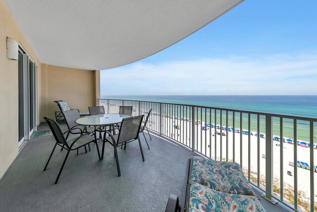 balcony with a water view and a view of the beach