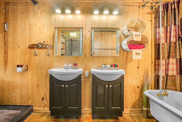 bathroom featuring wood walls, a tub, and double vanity