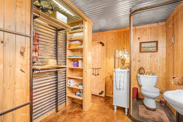 bathroom with wood walls and toilet