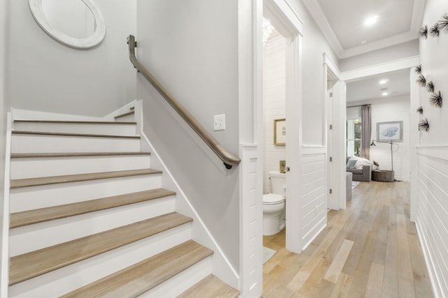 staircase with crown molding and hardwood / wood-style floors