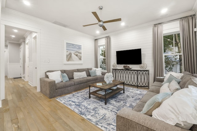 living room featuring crown molding, ceiling fan, plenty of natural light, and light wood-type flooring